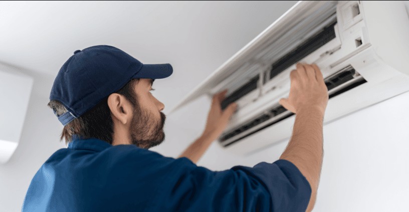 Technicien en train de réparer ou d’installer un climatiseur mural intérieur